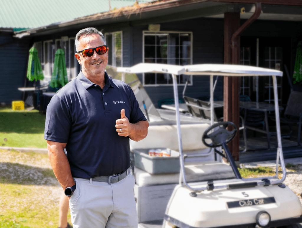 A Troika team member giving a thumbs up at a company golf event.